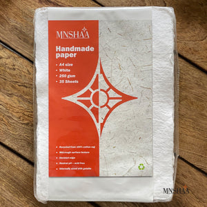 An image of pack of Mnshaa handmade paper. 100% cotton rag, Rough texture and four deckled edges, mid-rough texture and a heavyweight 250 gsm. Entirely unique in tone and grain. Perfect for use with watercolour, inks and other drawing media. Use as drawing paper, writing paper, art and craft paper. Suitable gift for all occasions and Christmas gift for both budding artists and professional artists. 