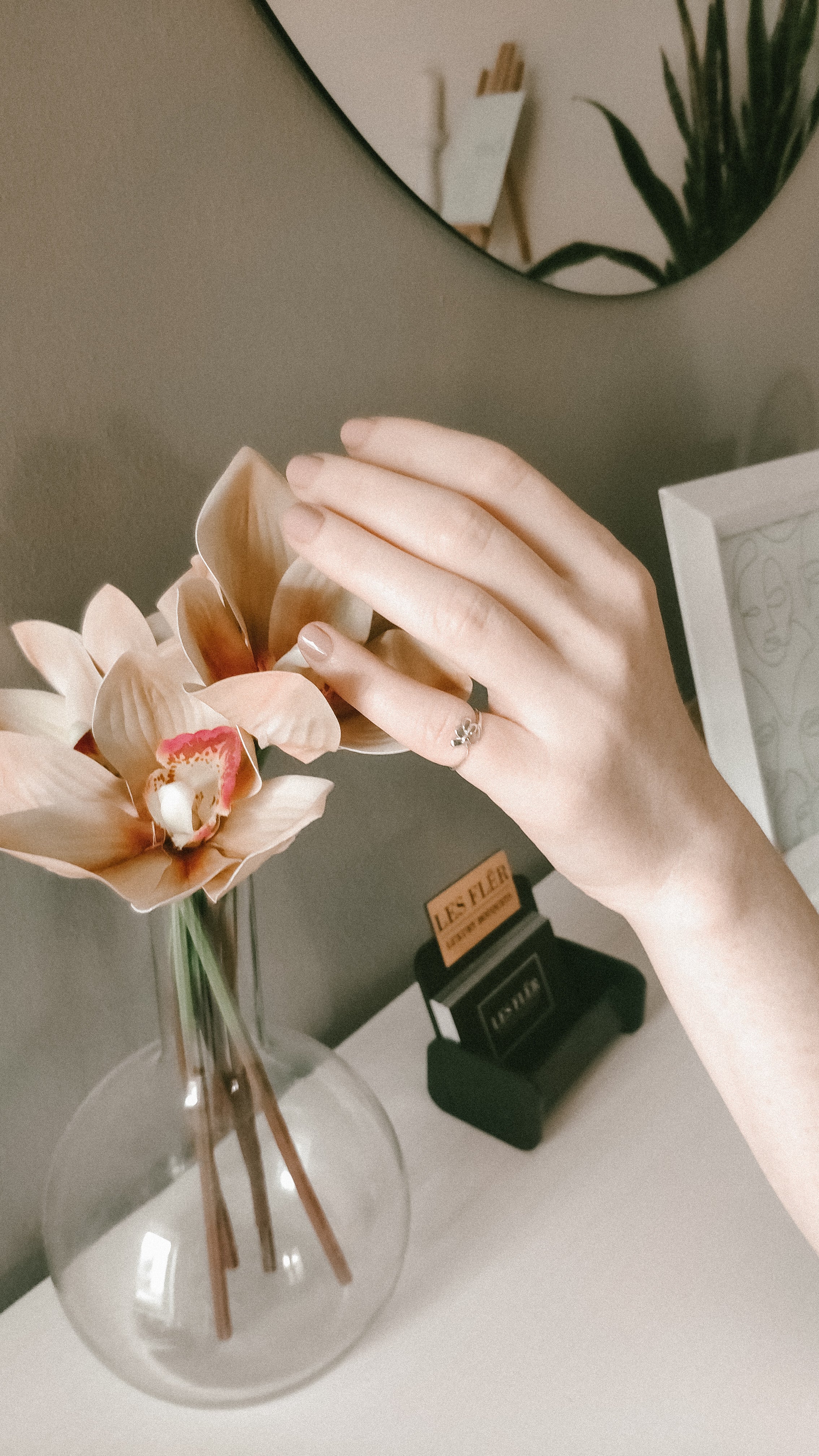An image of a lady's hand wearing Mnshaa Quattro Petali handmade sterling silver ring. Image is near the flower vase.